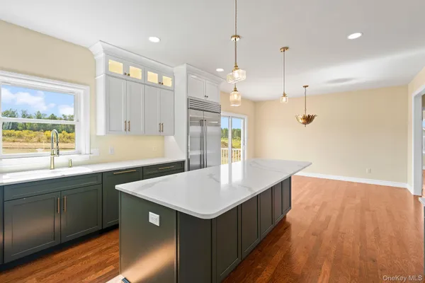a kitchen with a sink a counter space wooden floor and a window