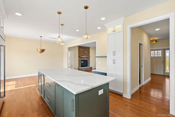 a open kitchen with a refrigerator a sink and wooden floor