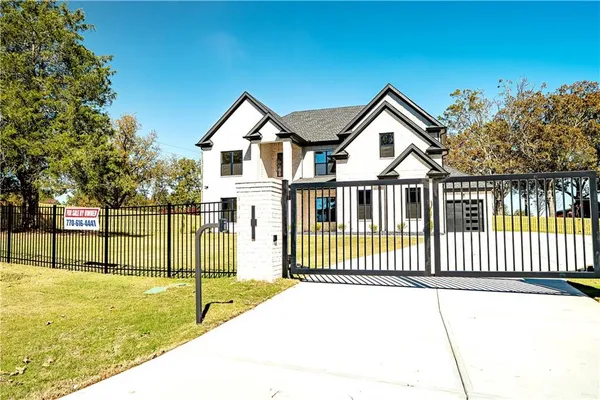 a view of a house with a small yard and fence