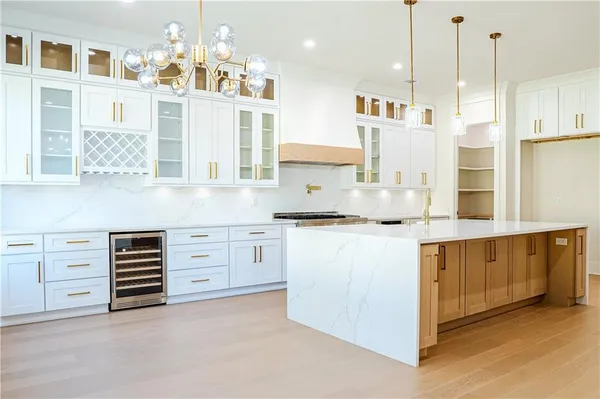 a kitchen with cabinets stainless steel appliances and a chandelier