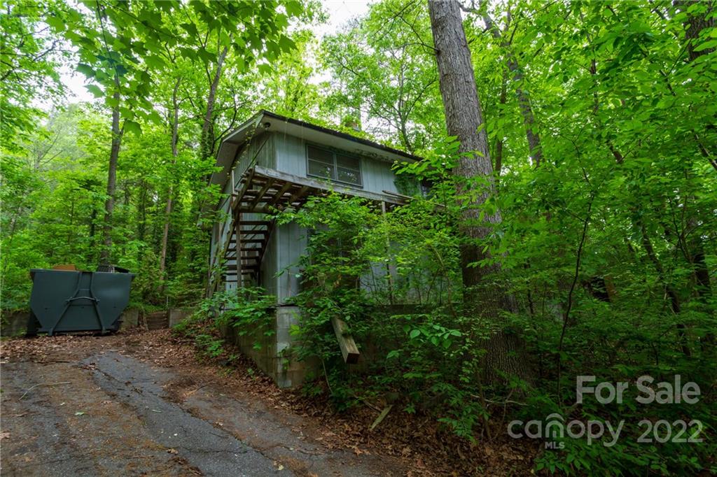 a house is sitting in middle of forest
