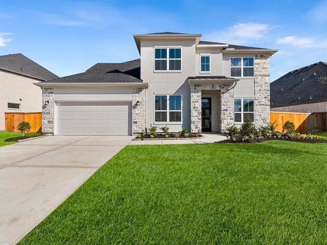 a front view of a house with garage and garden