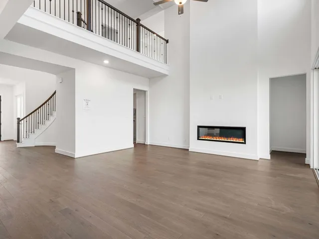 a living room with stainless steel appliances kitchen island granite countertop a refrigerator and a sink