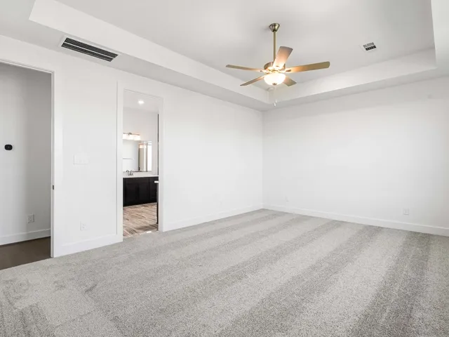 an empty room with a window and a ceiling fan