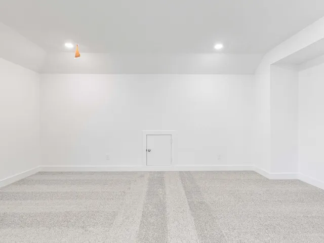 an empty room with chandelier fan and windows