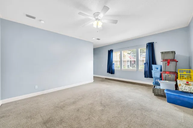 a living room with patio furniture and a floor to ceiling window