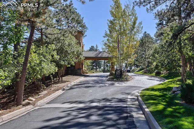 a front view of a house with a yard and fountain in middle