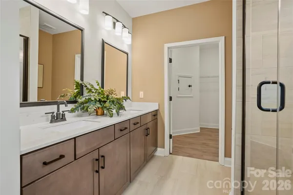 a bathroom with a double vanity sink mirror and next to a window