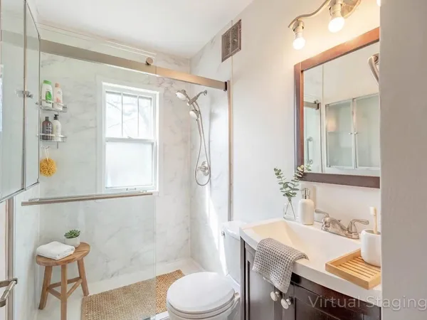 a bathroom with a granite countertop sink toilet a mirror and shower