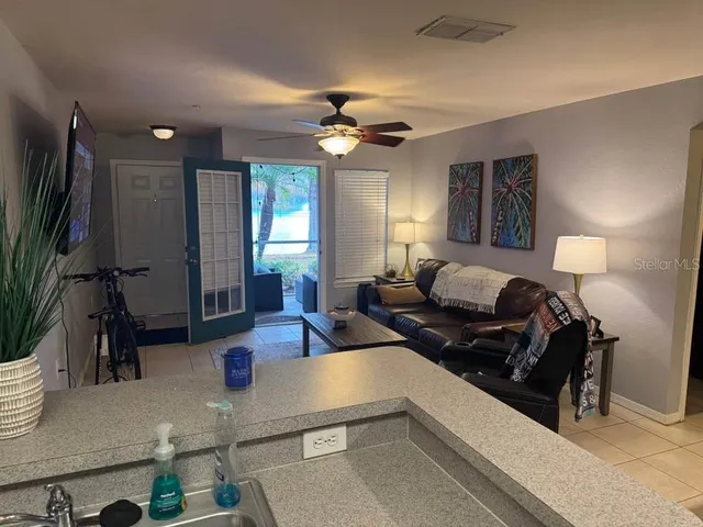 a living room with furniture a chandelier and a flat screen tv
