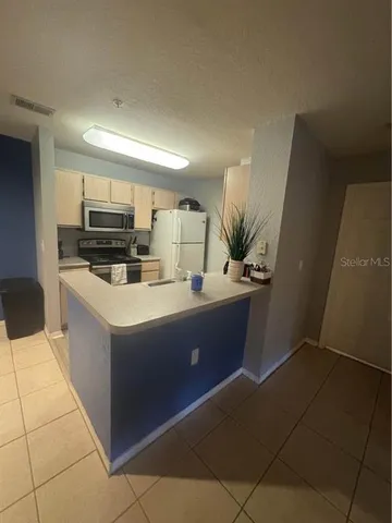 a kitchen with stainless steel appliances a sink a microwave a refrigerator and a stove