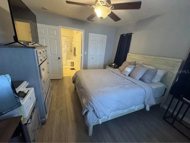 a bedroom with a bed flat screen tv and a window