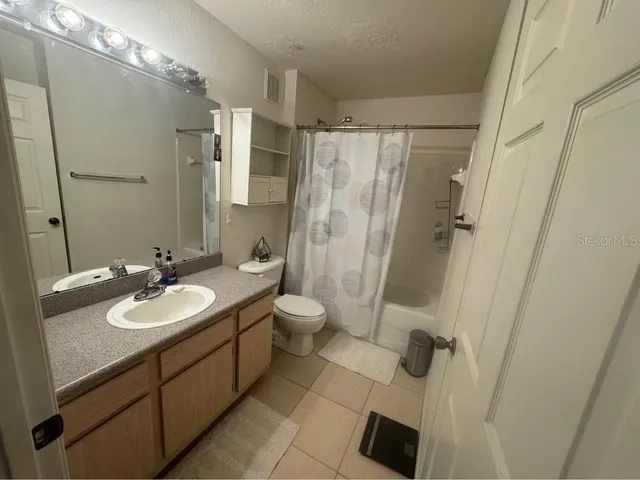 a bathroom with a sink a toilet a mirror and shower