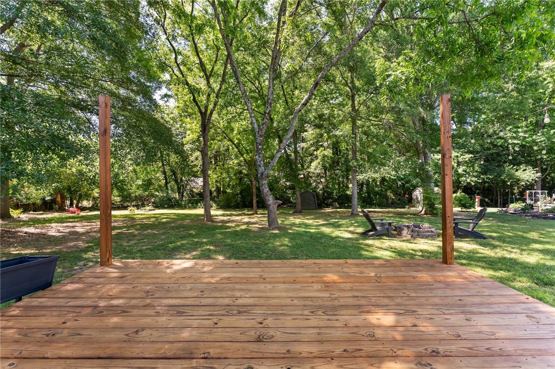 47 A Main Street Pelzer, SC 29669 - Photo 5 of 27 This spacious deck offers a tranquil view of the lush, tree-filled yard and fire pit area.