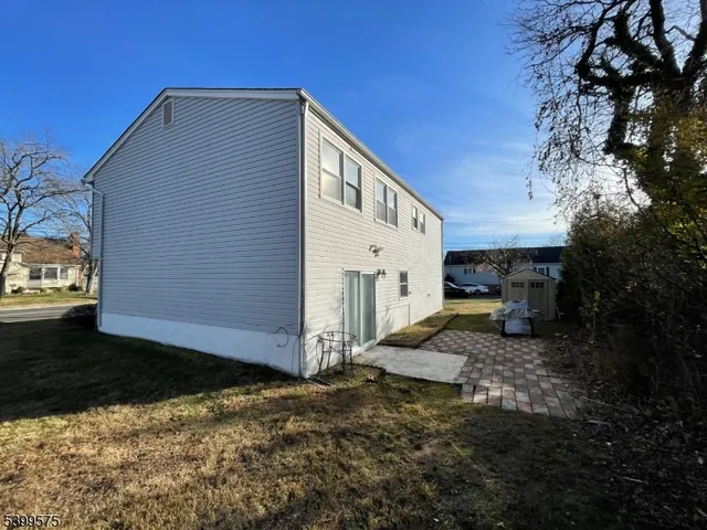 a view of a house with backyard and trees