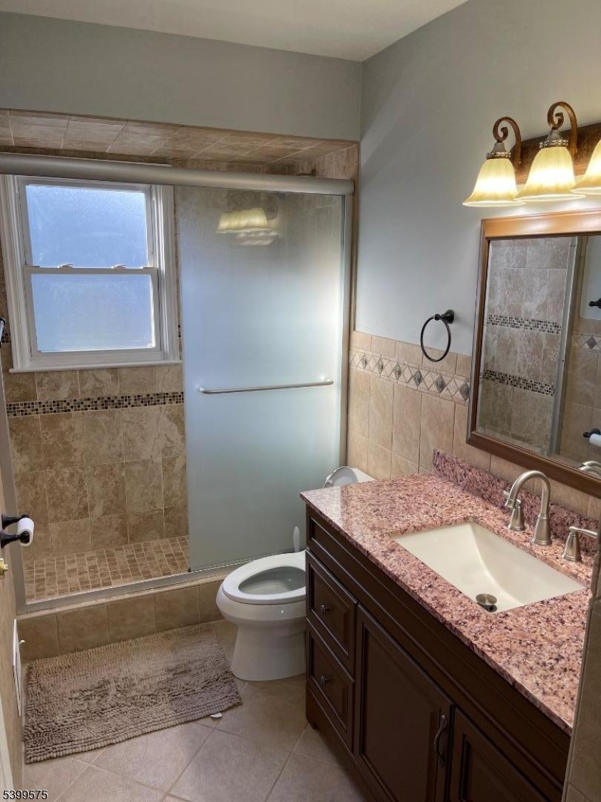 57 Greenbrook Road Middlesex, NJ 08846 - Photo 8 of 14 a bathroom with a granite countertop sink a toilet and shower