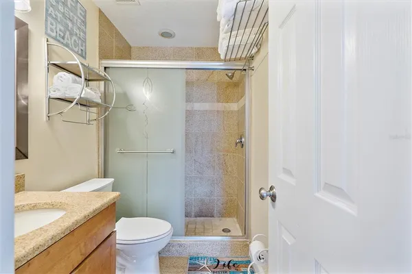 a bathroom with a granite countertop shower toilet and sink