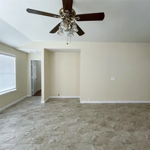 an empty room with a ceiling fan and a window