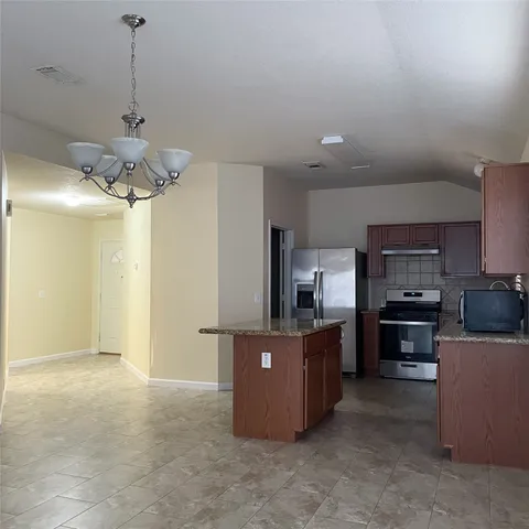 a kitchen with kitchen island a counter top space appliances and cabinets