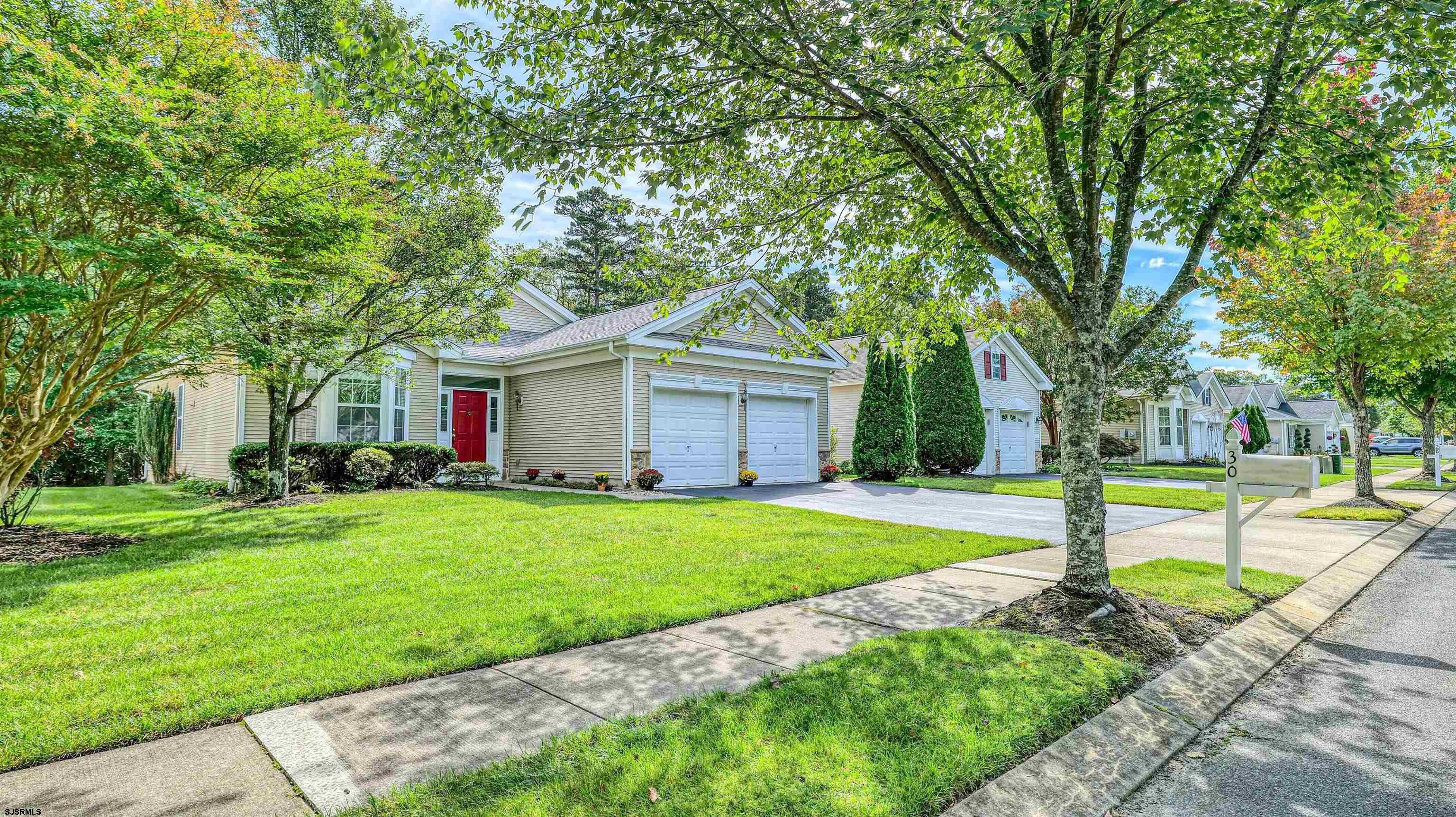 a front view of a house with a yard and trees