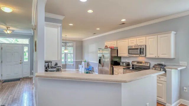 a kitchen with cabinets a sink a window and stainless steel appliances