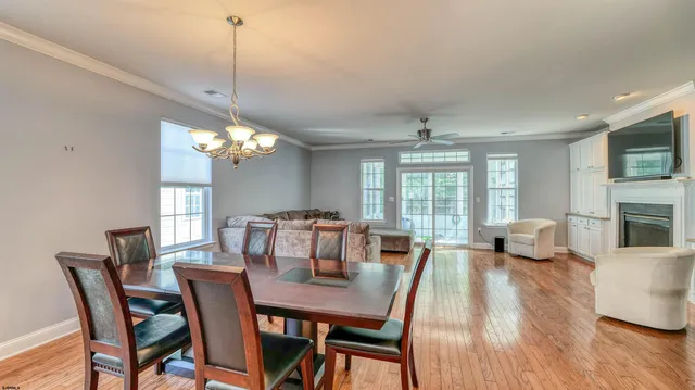 a view of a dining room with furniture a chandelier and wooden floor