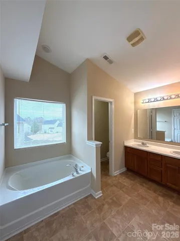 a view of spacious bathroom with bathtub and shower