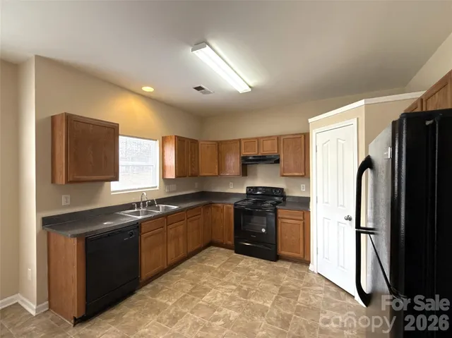 a kitchen with stainless steel appliances granite countertop a stove a refrigerator a sink a oven and dishwasher