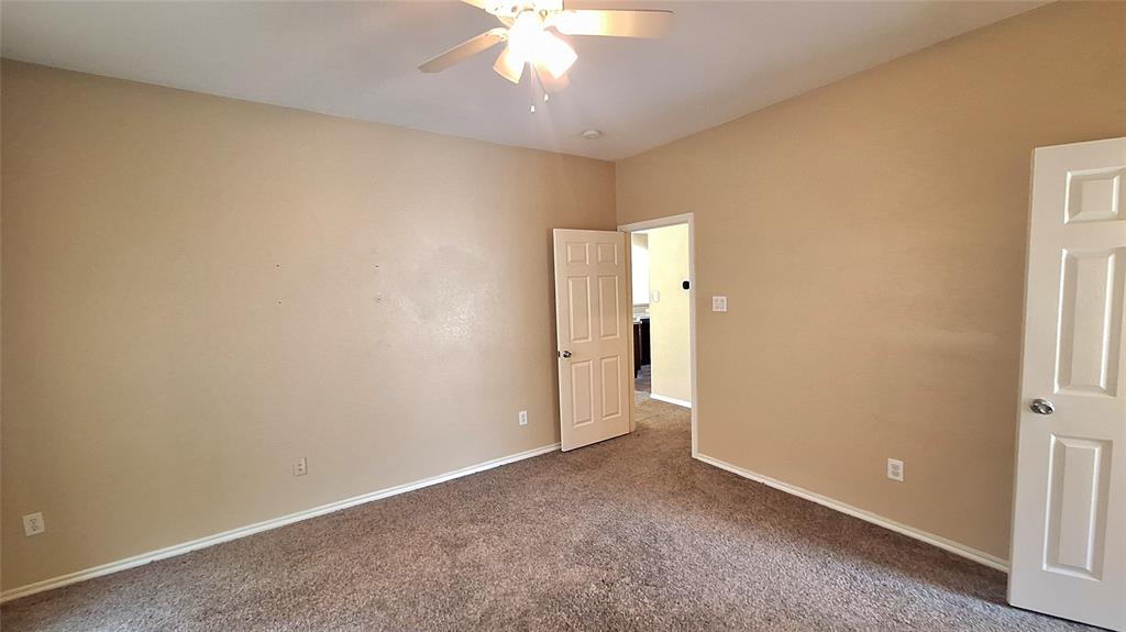 953 Hannah Way Dallas, TX 75253 - Photo 14 of 22 Spacious room featuring neutral tone walls, brown carpeting, and white baseboards