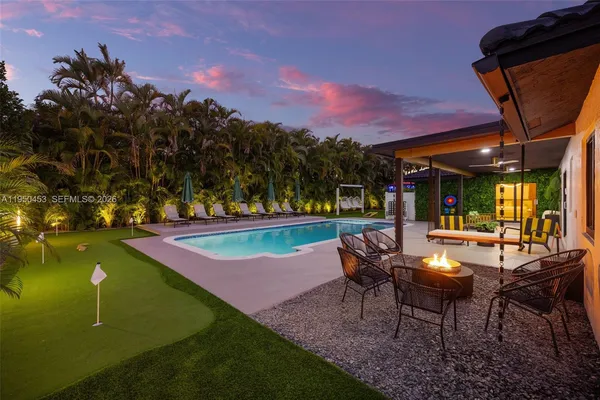 a white bed sitting in a room next to a window