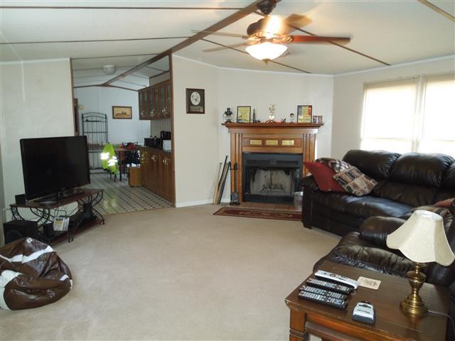 1818 Church Road Clarksville, TN 37040 - Photo 6 of 20 Living room offers corner fireplace, vaulted ceiling, ceiling fan, carpet.