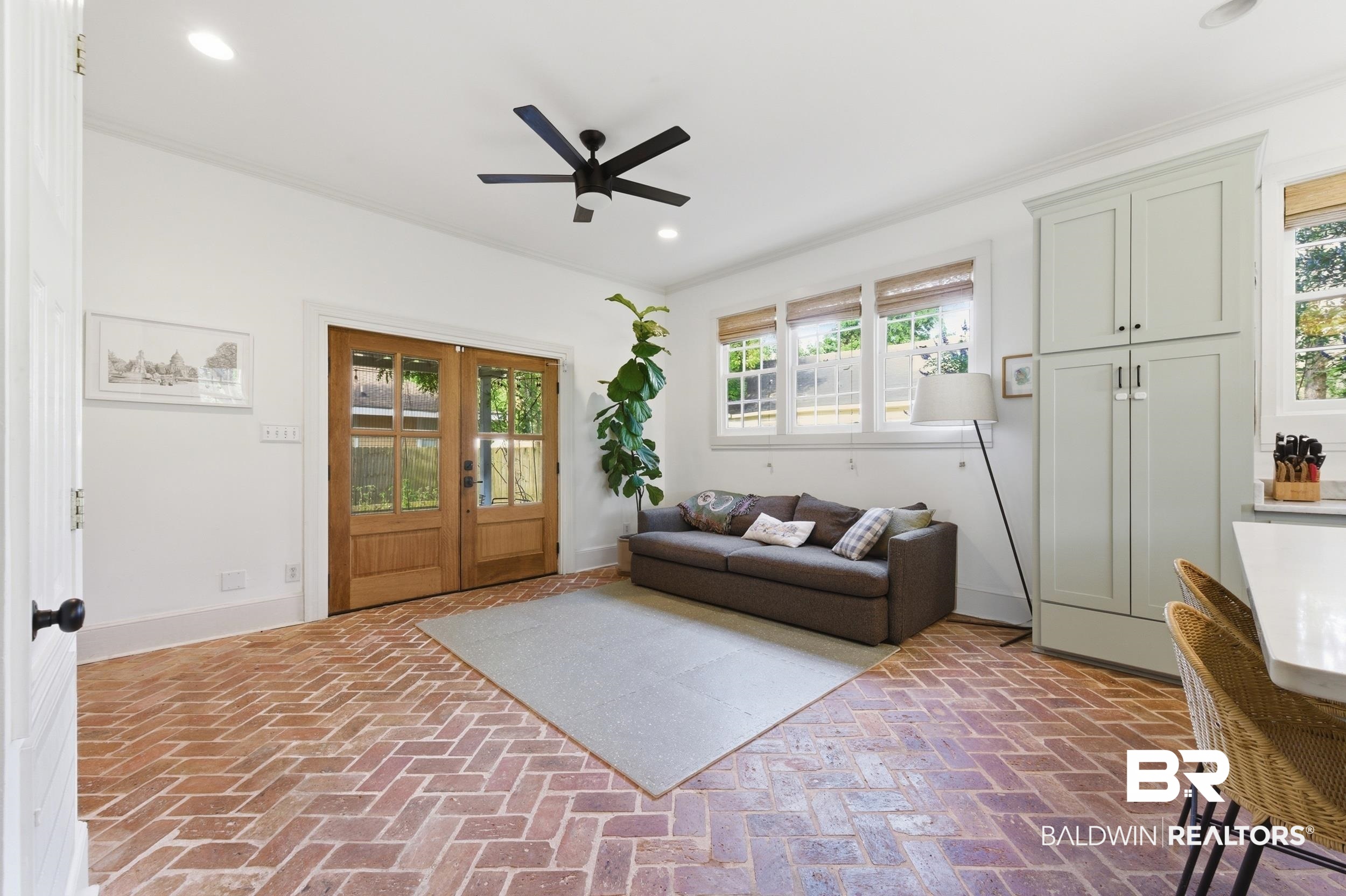 350 Charles Street Mobile, AL 36604 - Photo 6 of 52 Brick herringbone pattern flooring defines this open concept space, featuring wood-framed French doors and recessed lighting