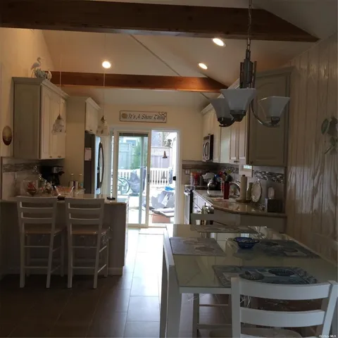 a kitchen with kitchen island granite countertop a sink cabinets and stainless steel appliances