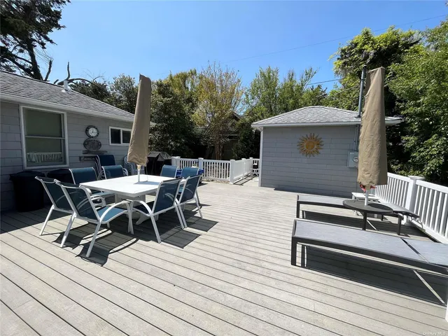 a view of a roof deck with table and chairs with wooden floor and fence