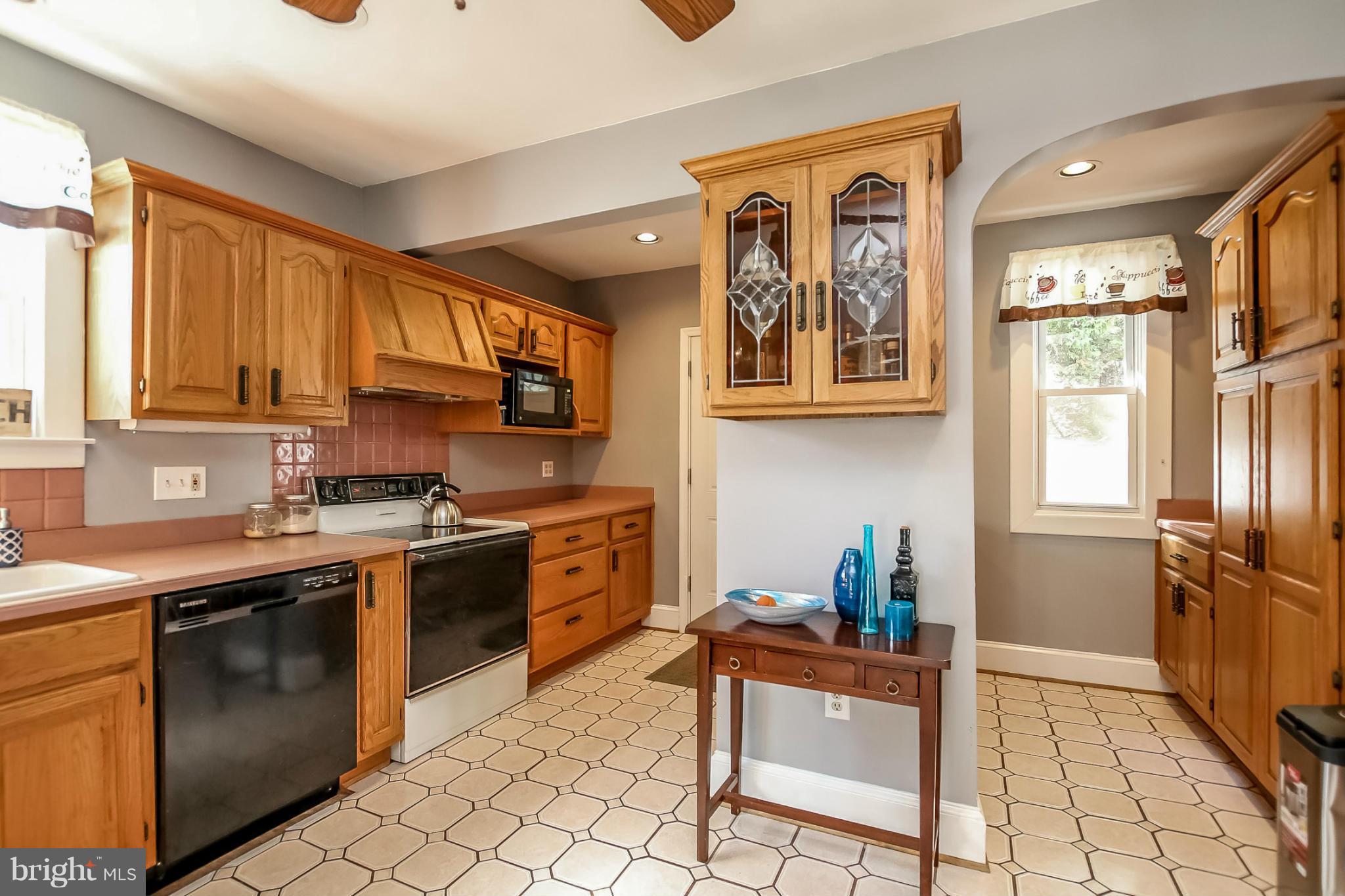 814 Dorchester Road Baltimore, MD 21229 - Photo 11 of 30 a kitchen with stainless steel appliances granite countertop a stove top oven a sink a dining table and chairs with wooden floor