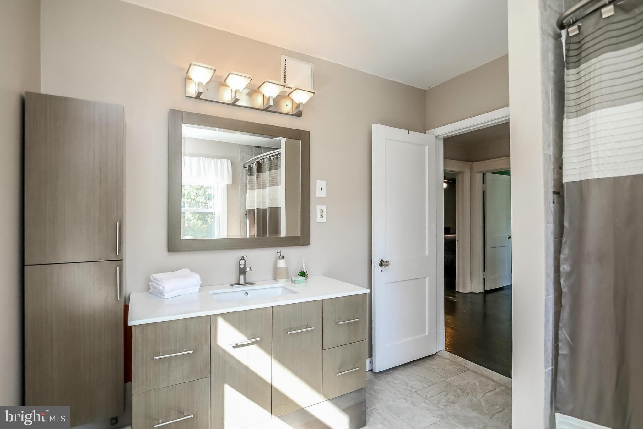 814 Dorchester Road Baltimore, MD 21229 - Photo 13 of 30 a bathroom with a sink vanity and a mirror