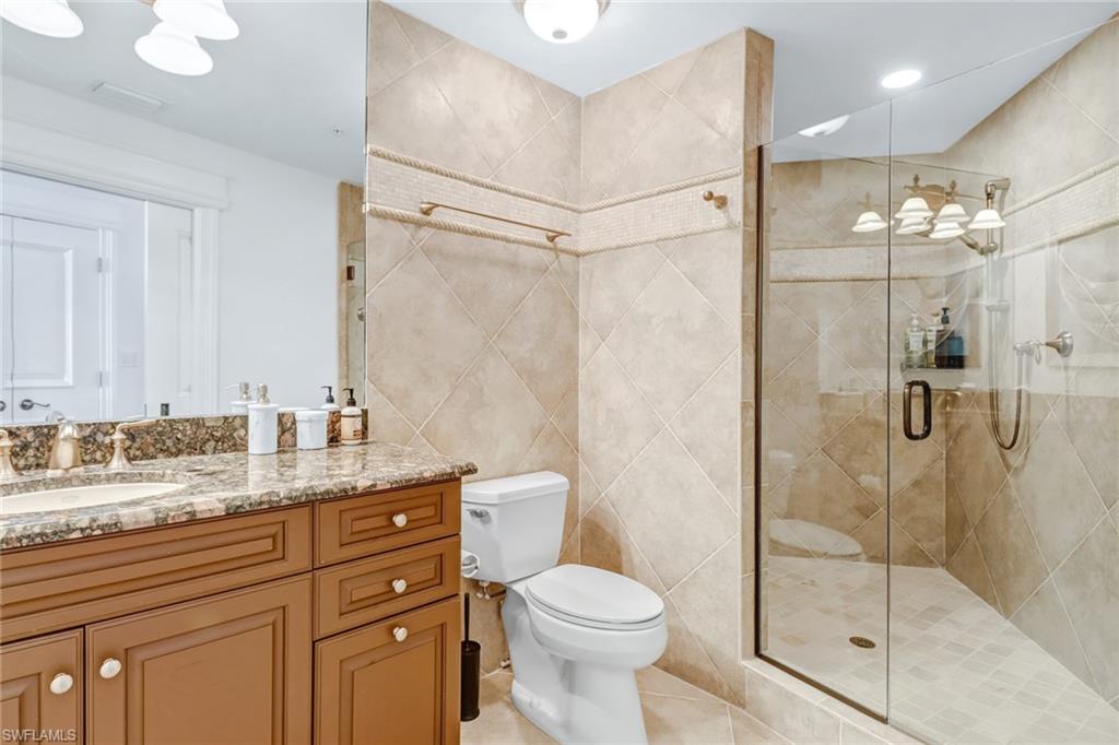 451 Bayfront Place, Unit 5307 Naples, FL 34102 - Photo 20 of 28 a bathroom with a granite countertop sink toilet and shower