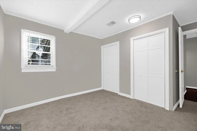 an empty room with a chandelier fan