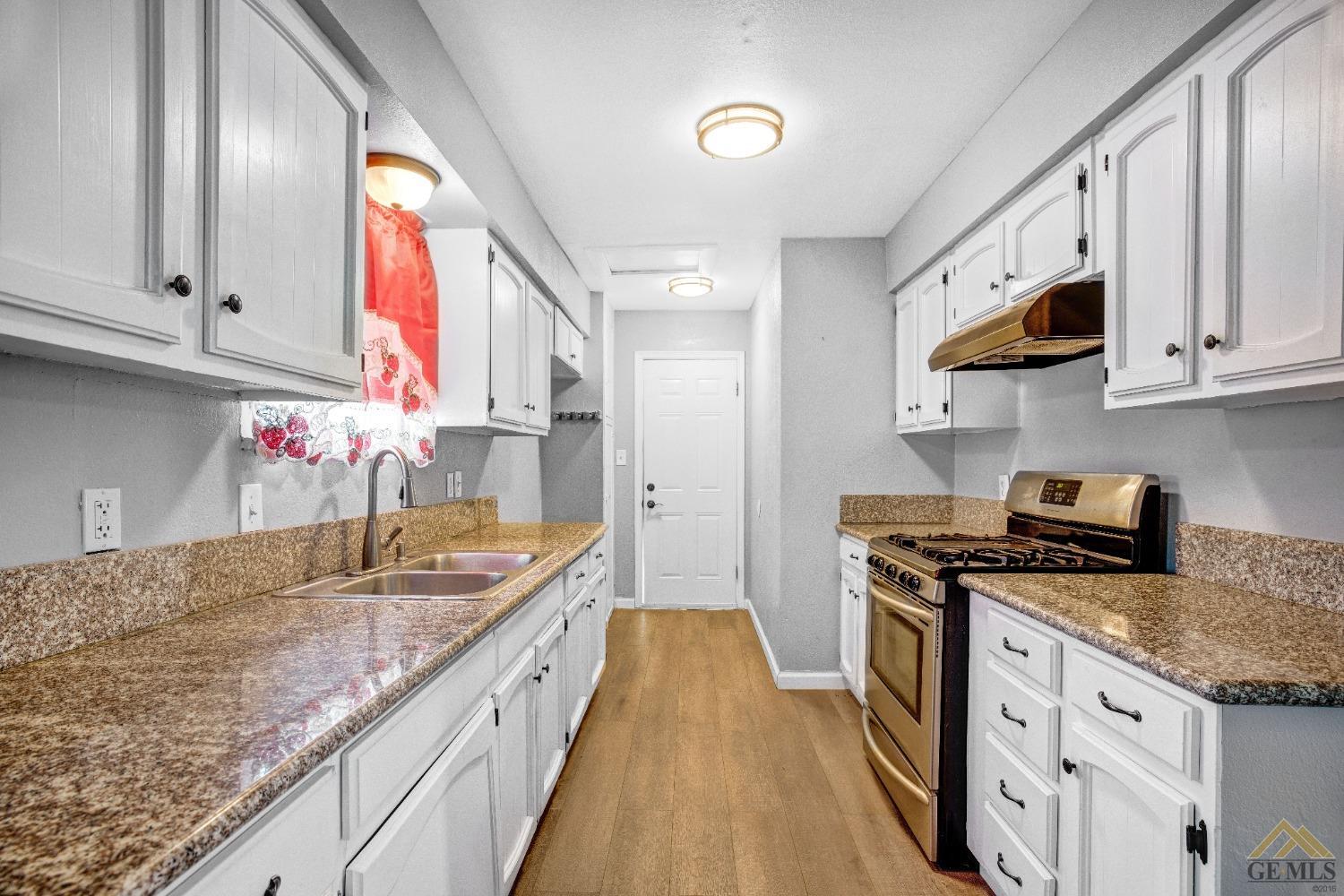 Undisclosed Address Taft, CA 93268 - Photo 15 of 24 a kitchen with stainless steel appliances granite countertop a sink stove and cabinets