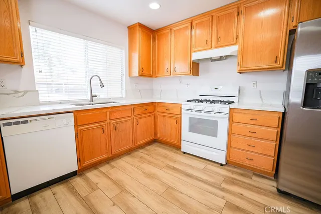 a kitchen with stainless steel appliances granite countertop a sink a stove and cabinets