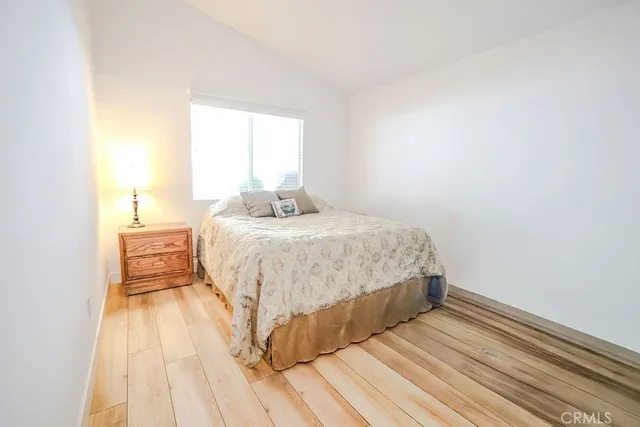 a bedroom with a bed and wooden floor
