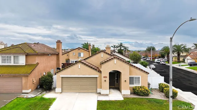 a view of a white house next to a yard with big trees