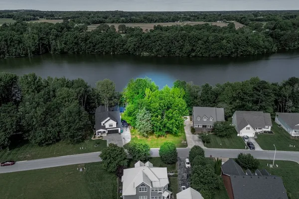 an aerial view of a house with a garden and a lake view