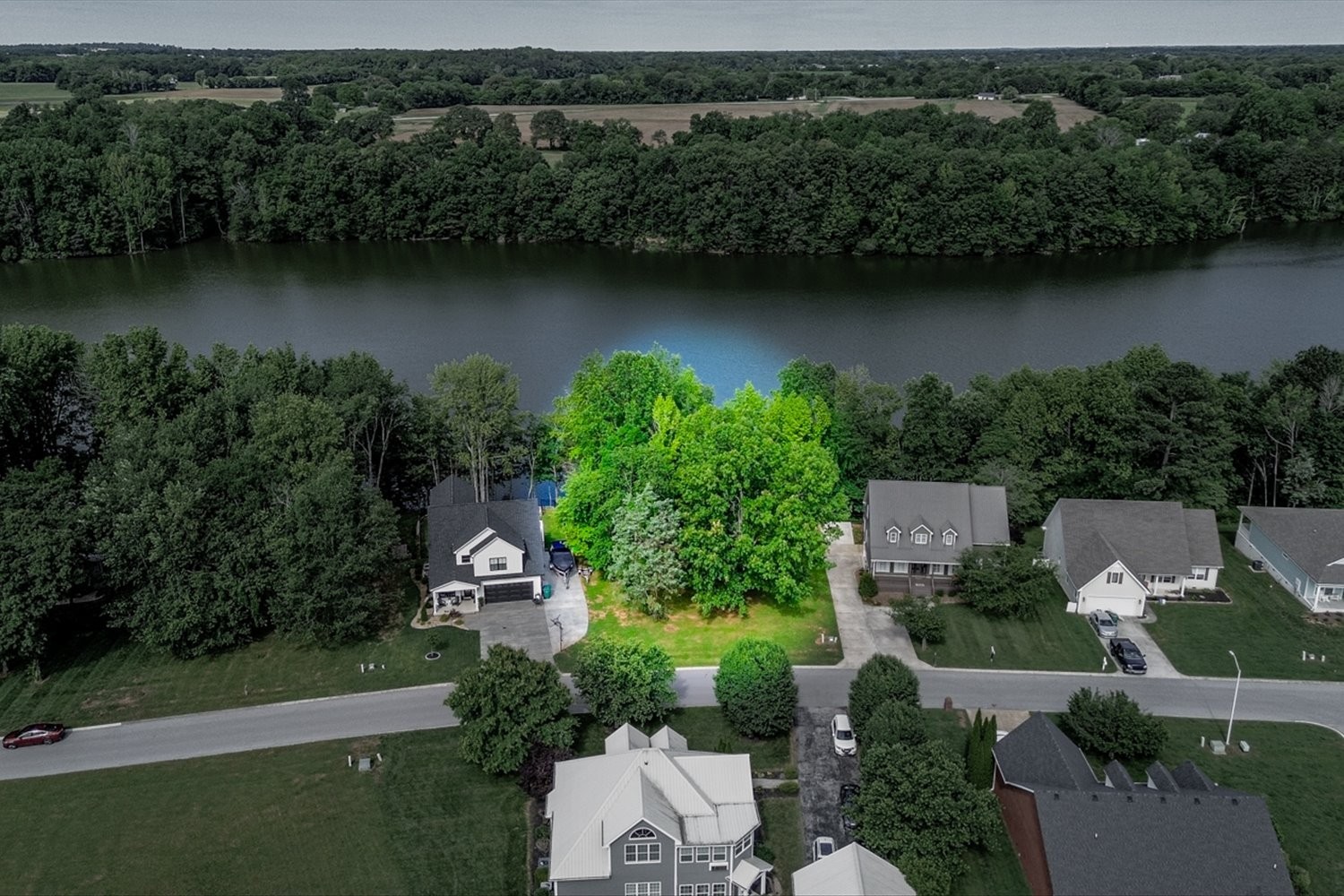 an aerial view of a house with a garden and a lake view