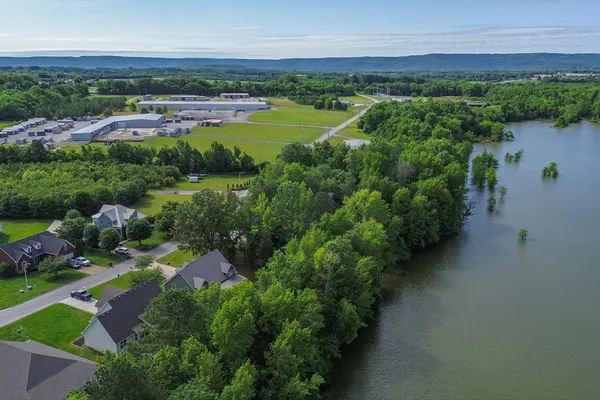 an aerial view of a houses with a yard and lake view