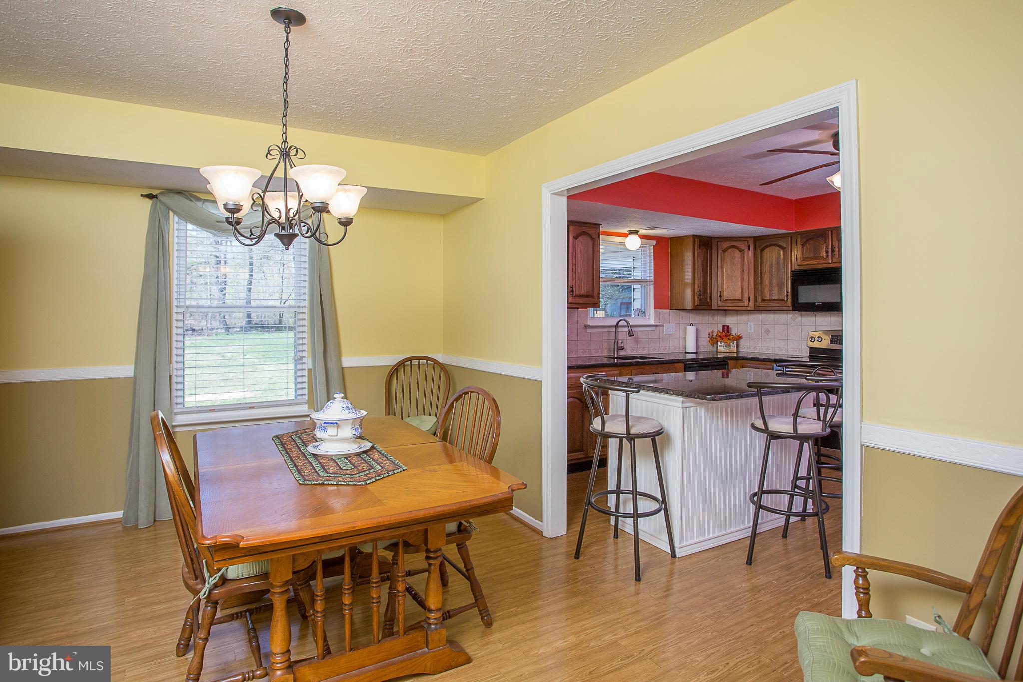 8208 Grassland Road Severn, MD 21144 - Photo 5 of 30 a dining room with furniture a chandelier and wooden floor