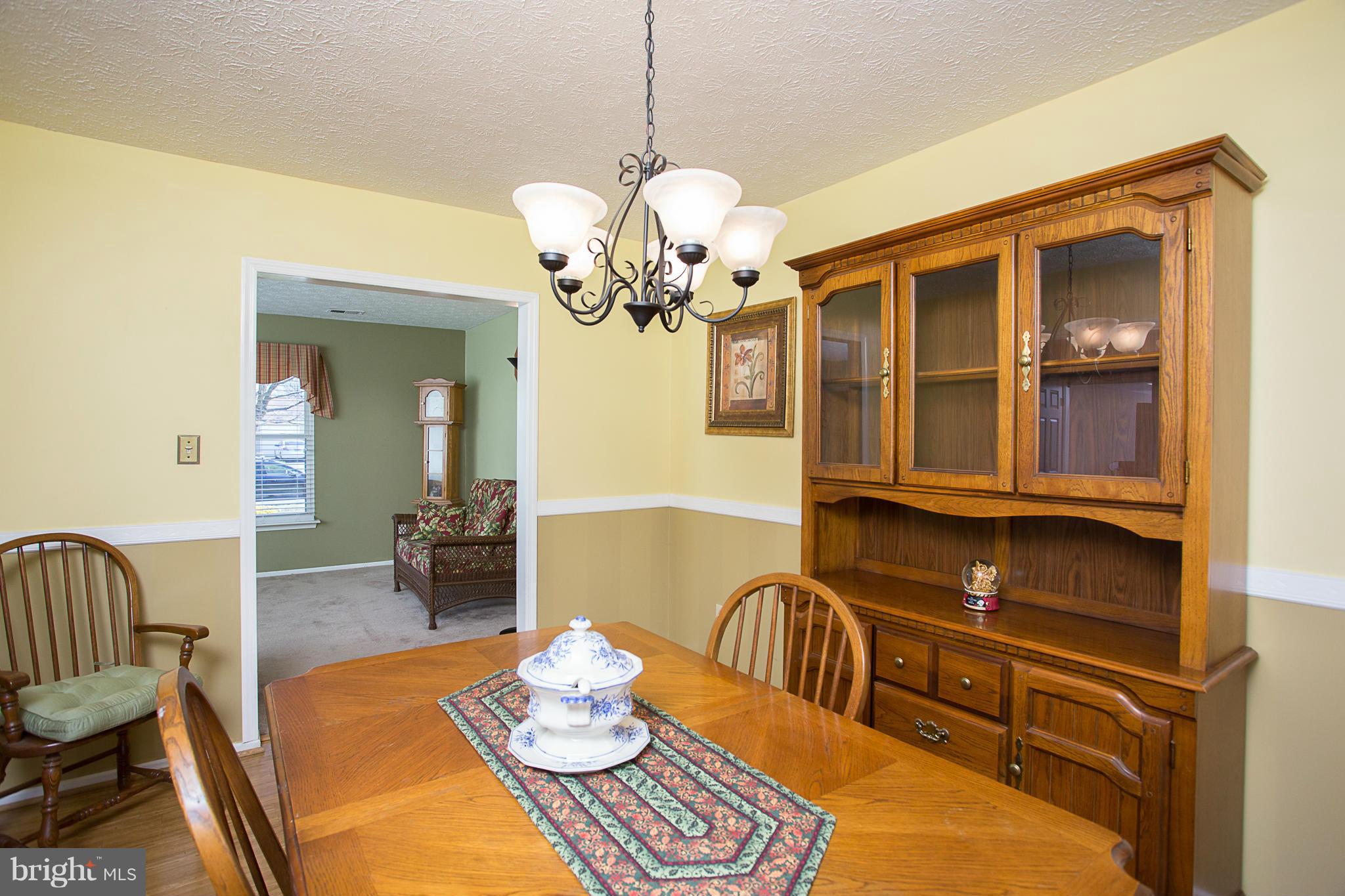 8208 Grassland Road Severn, MD 21144 - Photo 6 of 30 a view of a dining room with furniture a chandelier and wooden floor