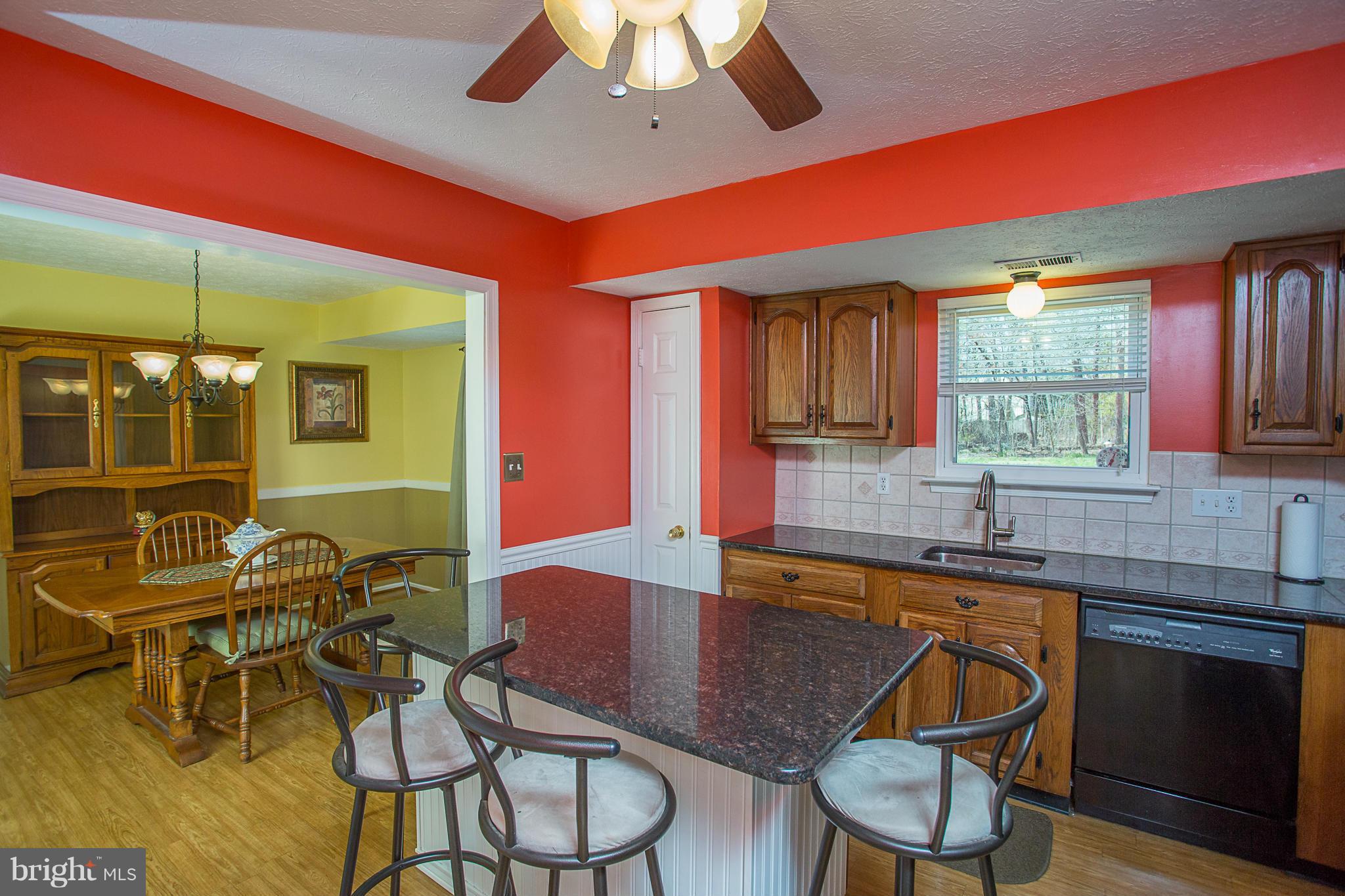 8208 Grassland Road Severn, MD 21144 - Photo 8 of 30 a kitchen with stainless steel appliances granite countertop a dining table chairs and a sink