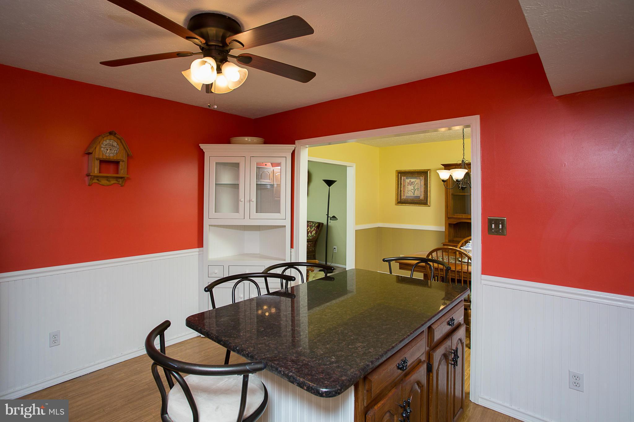8208 Grassland Road Severn, MD 21144 - Photo 9 of 30 a kitchen with a table chairs and a refrigerator