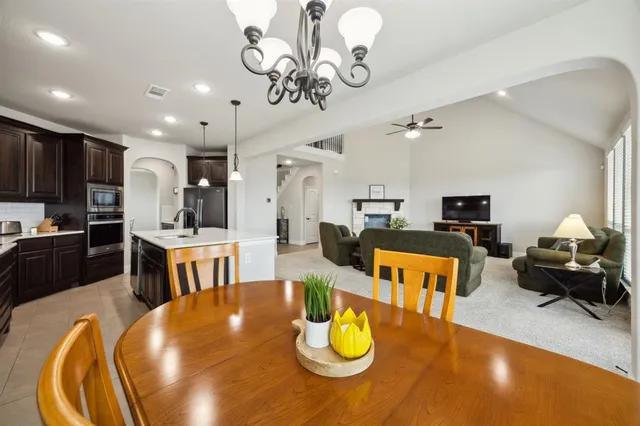 a living room with dining table furniture and a kitchen view